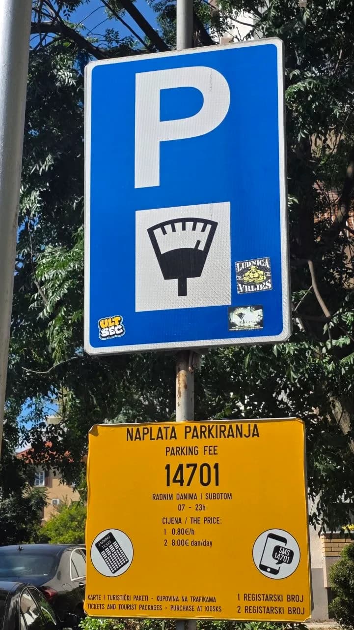 Žuta tabla sa oznakom zone 14701, radnim vremenom naplate i cijenom po satu i danu, ispod plavog znaka za naplatu parkiranja